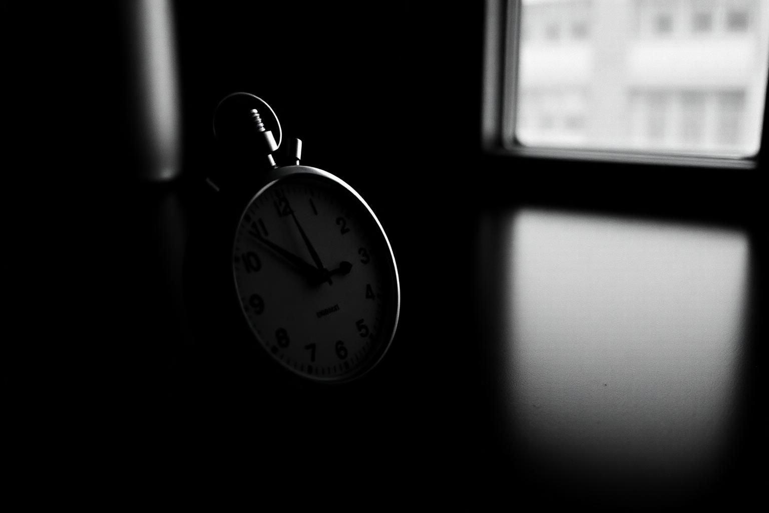 Analog stopwatch in dramatic low light — time running out